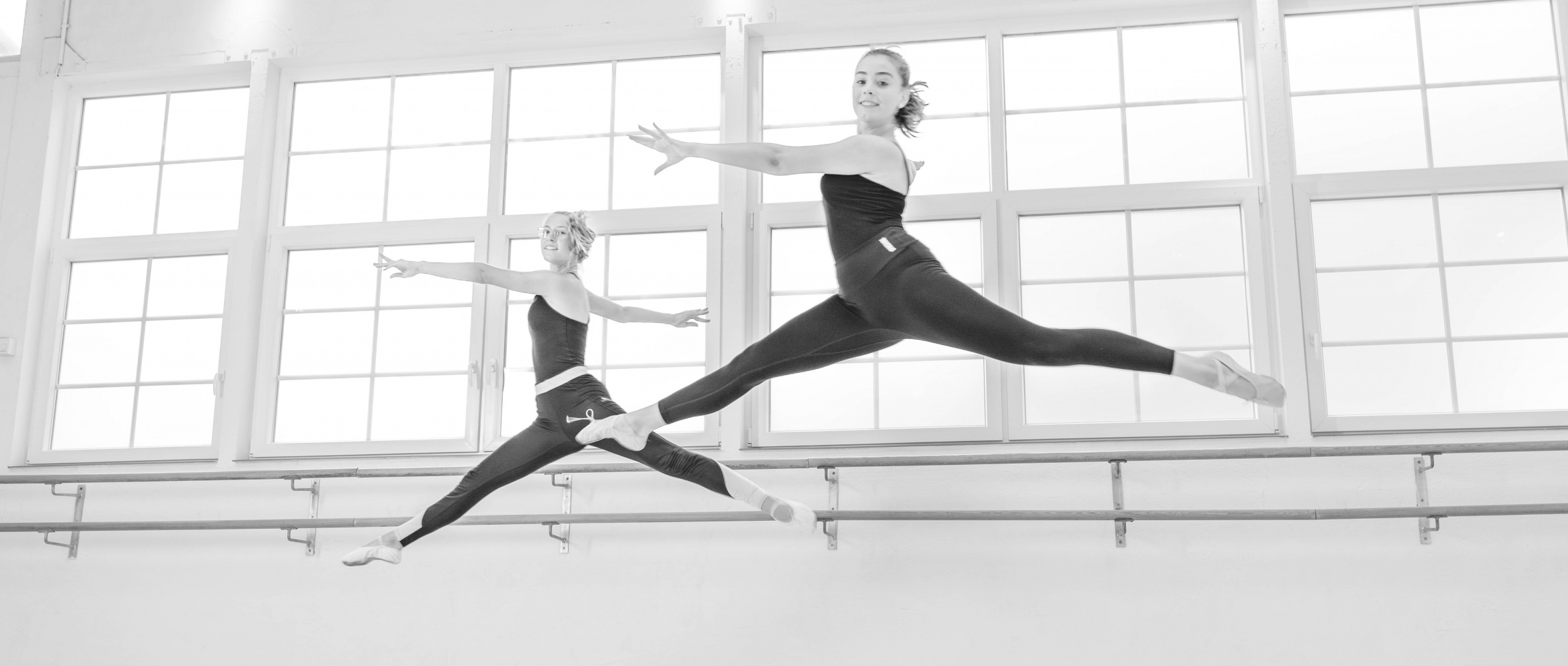 Zwei Ballettschülerinnen im Spagatsprung im Tanzstudio Köln