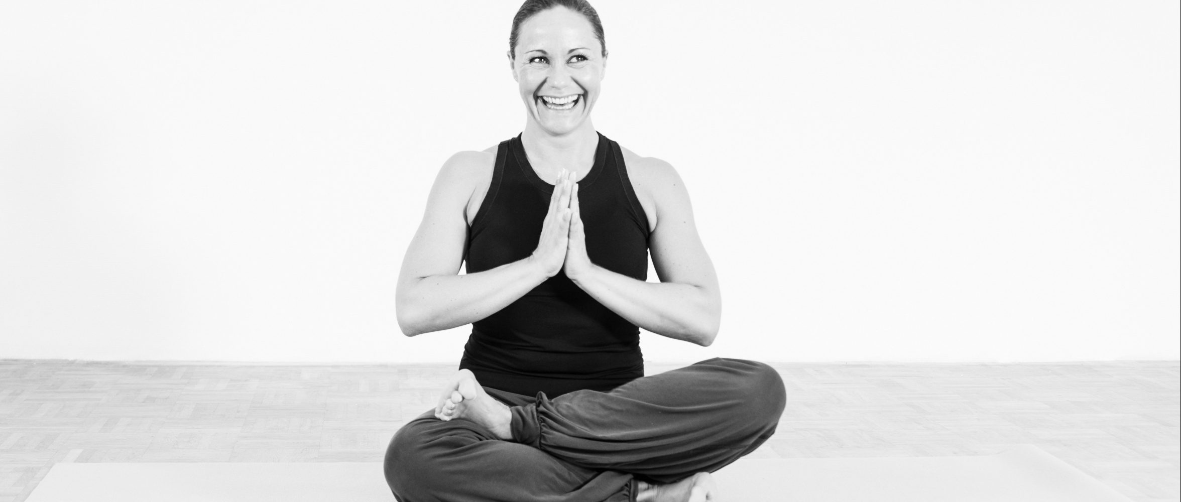 Teilnehmerin sitzt im halben Lotussitz beim Yoga-Kurs Siegburg