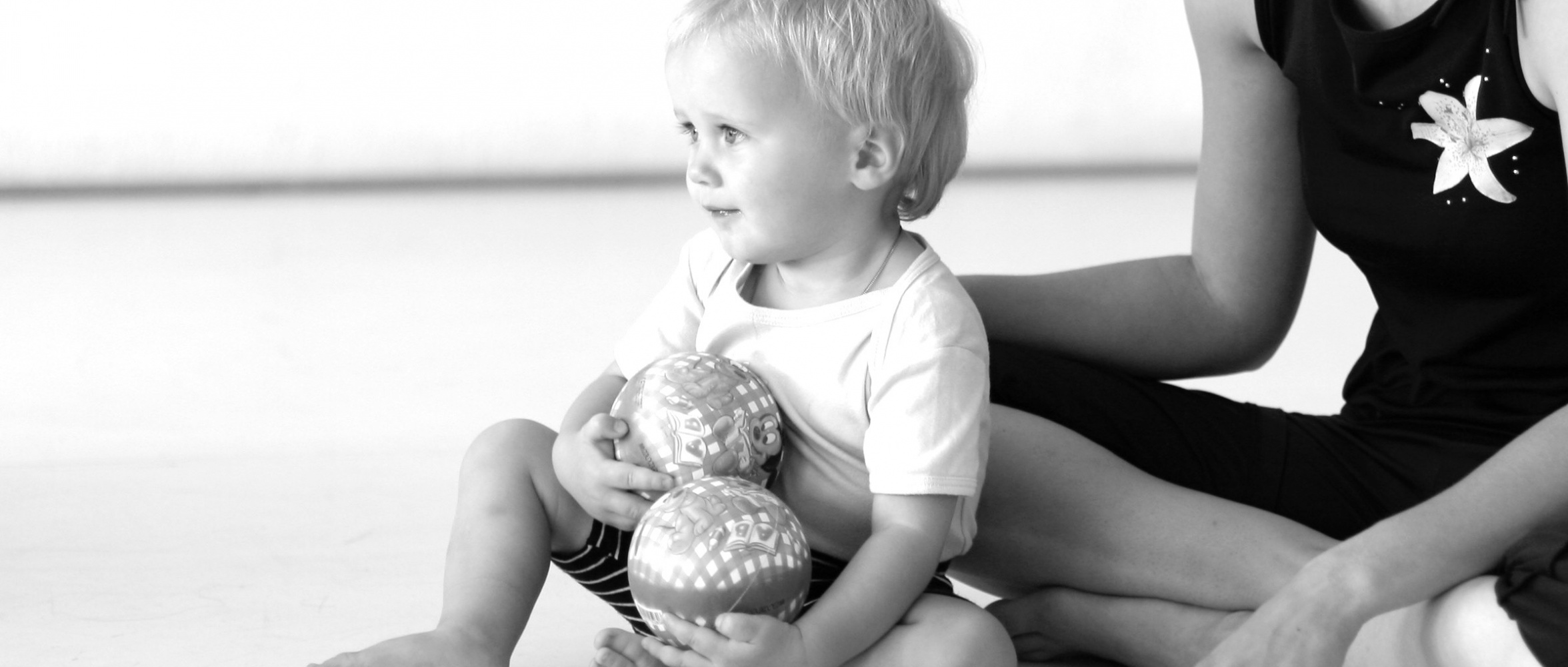 Kind spielt mit Ball im hellen Tanzsaal – erste Bewegungserfahrungen beim Eltern-Kind-Tanzkurs.