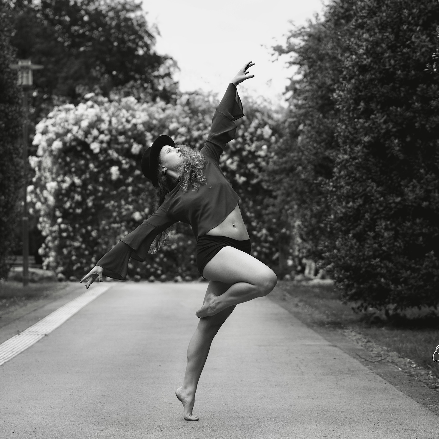Stella Kolodzey in dynamischer Modern-Dance-Pose mit Hut im Park